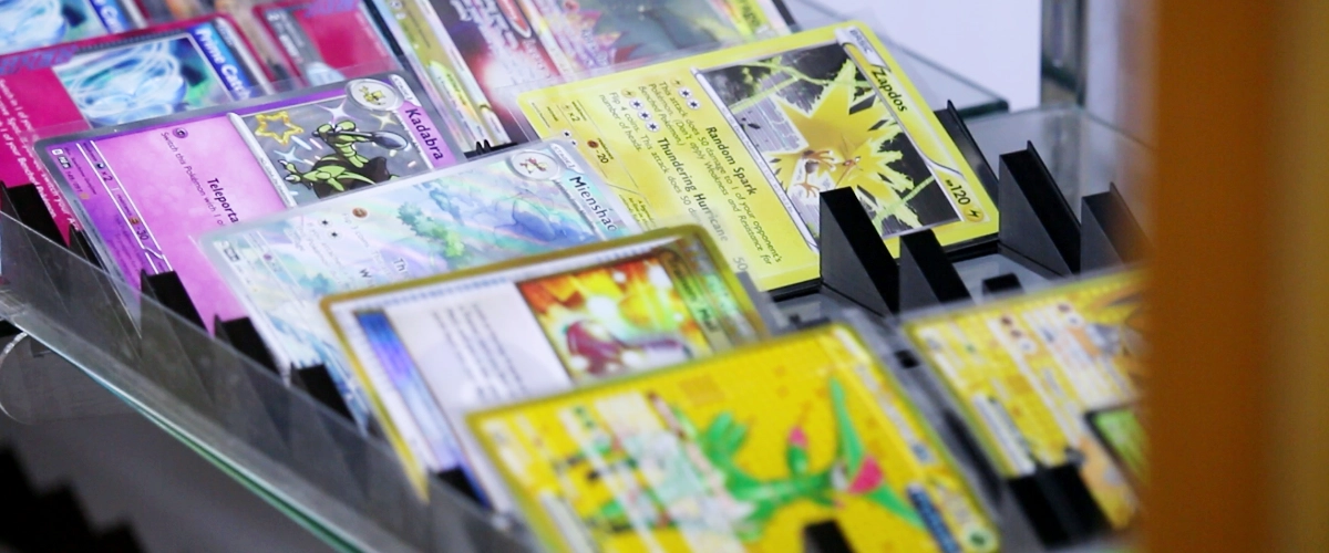 A collection of Pokémon cards behind glass.